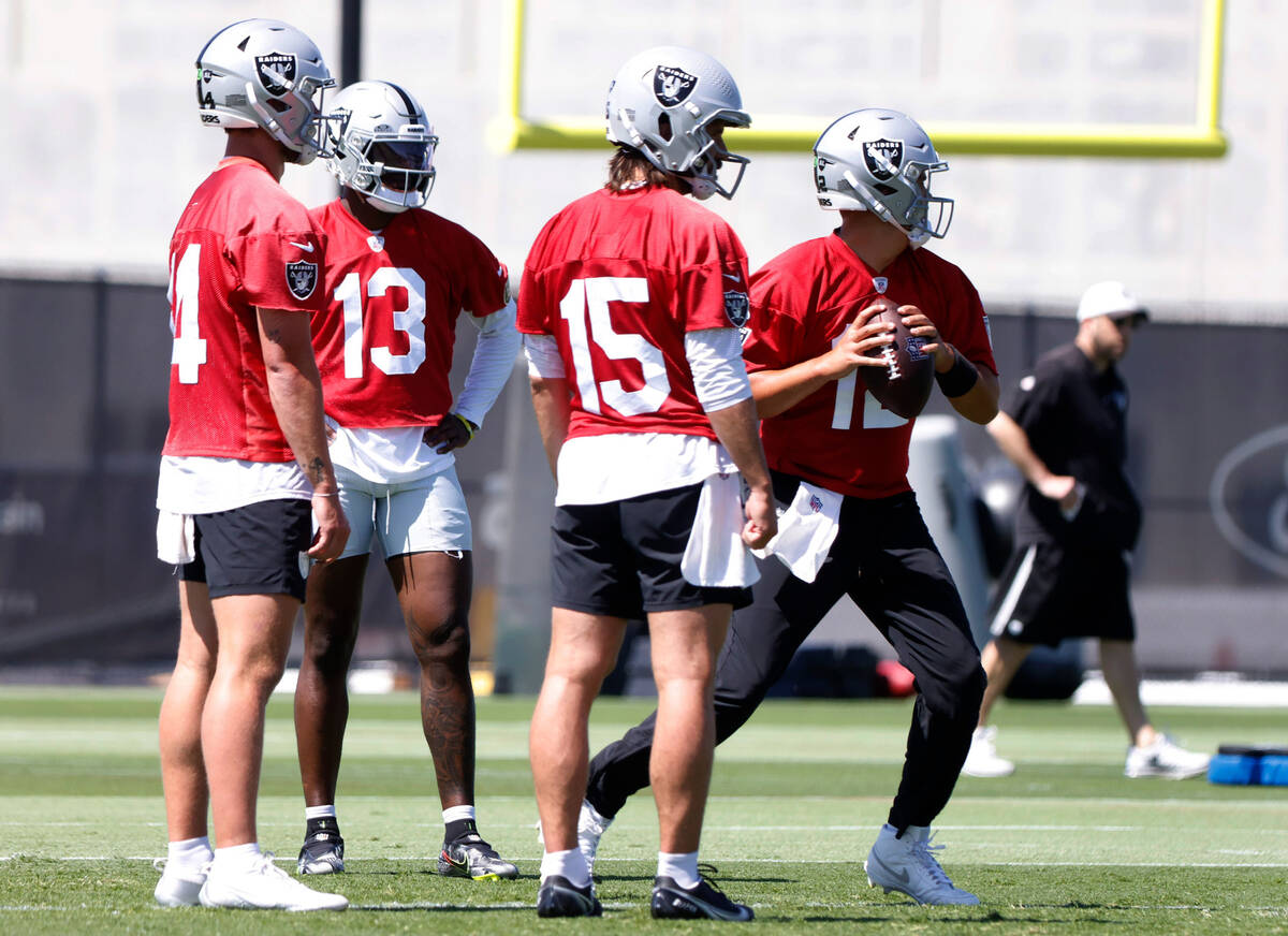 Raiders quarterback Aidan O'Connell (12) prepares to throw the ball as backup quarterbacks Anth ...