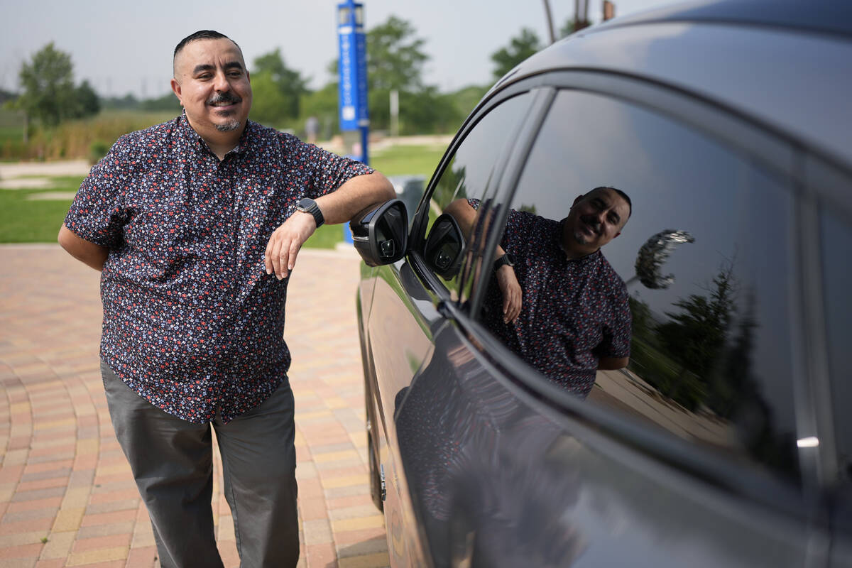 Jose Valdez, 45, who owns three EVs, poses with his Mustang Mach-E, Thursday, May 9, 2024, in S ...