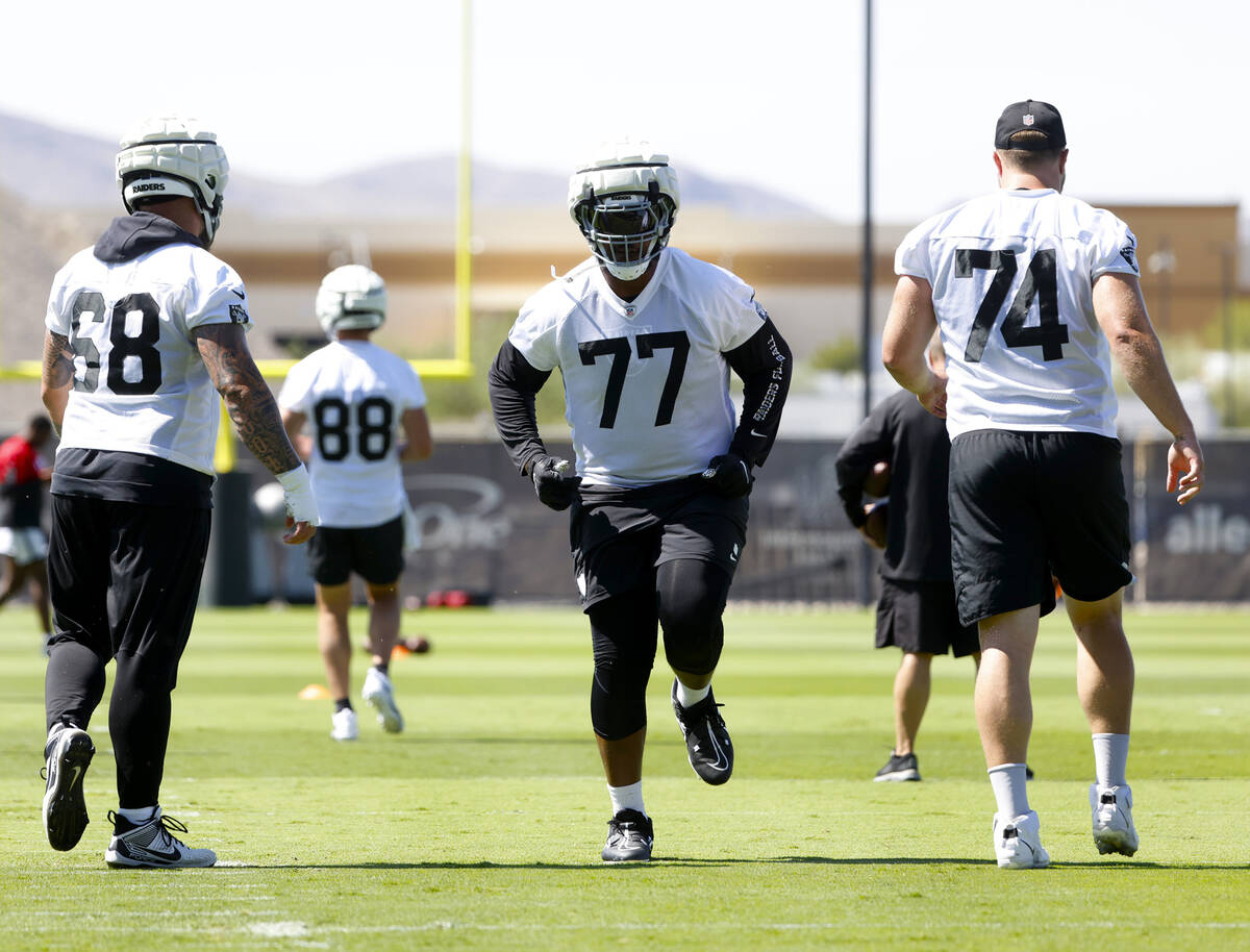 Raiders players, including offensive tackle Thayer Munford Jr. (77), warm up during organized t ...