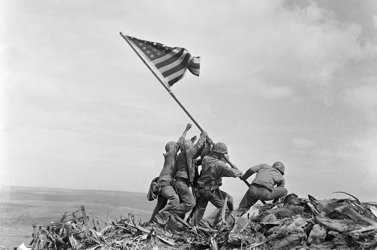 U.S. Marines of the 28th Regiment, 5th Division, raise a U.S. flag atop Mount Suribachi, Iwo Ji ...