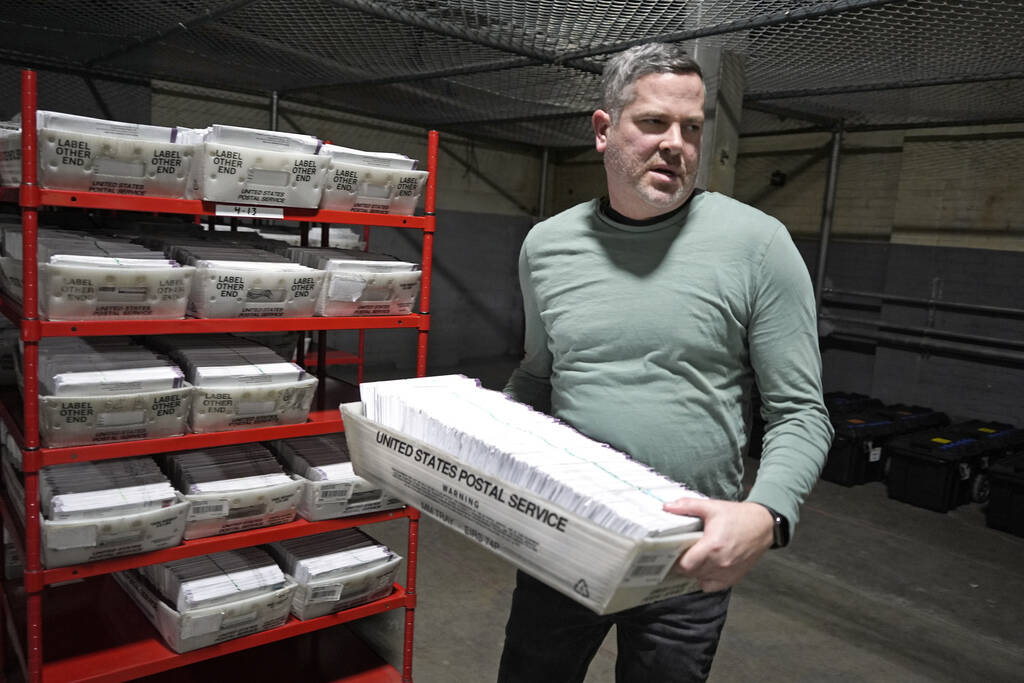 FILE - A man carries a container of mail-in ballots in Pittsburgh, April 18, 2024. The Republic ...