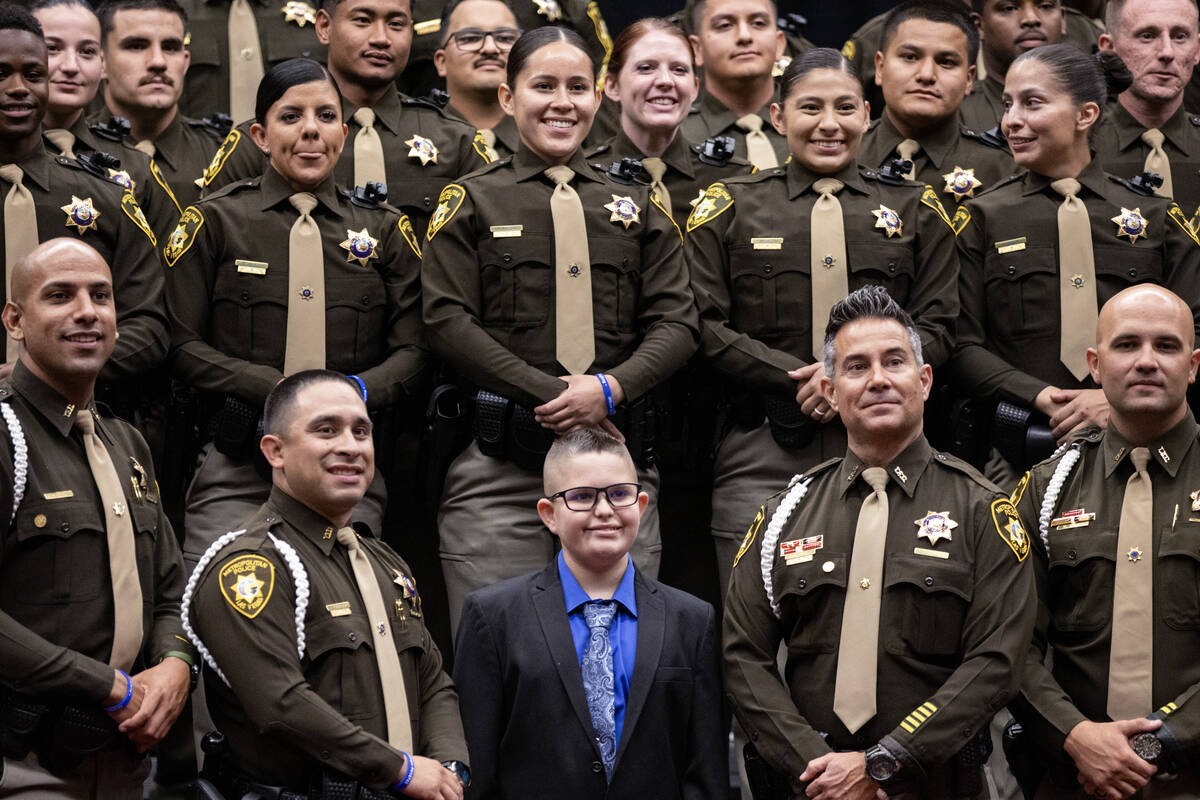 Staff and recent graduates take a photograph with Noah Swanger, 11, after the Las Vegas Metro P ...