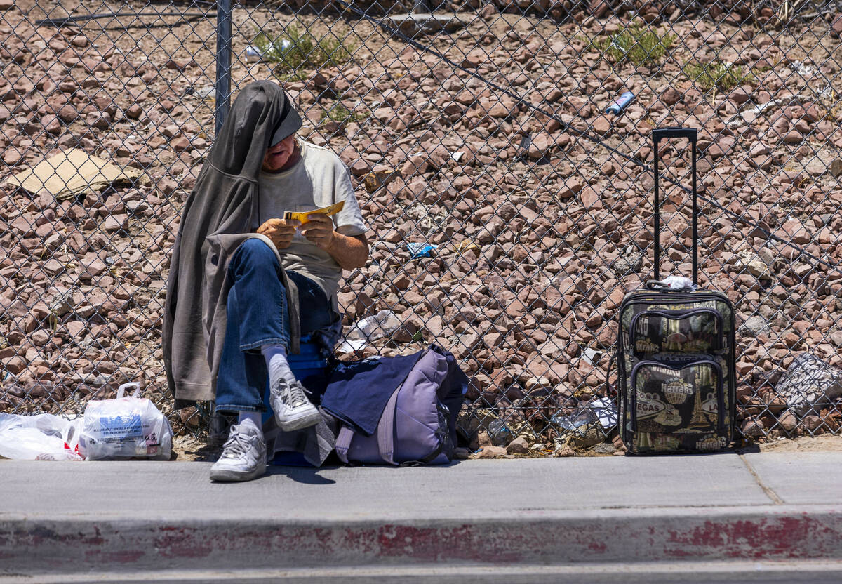 A homeless man checks out a "golden ticket" for services distributed by the Vegas Str ...