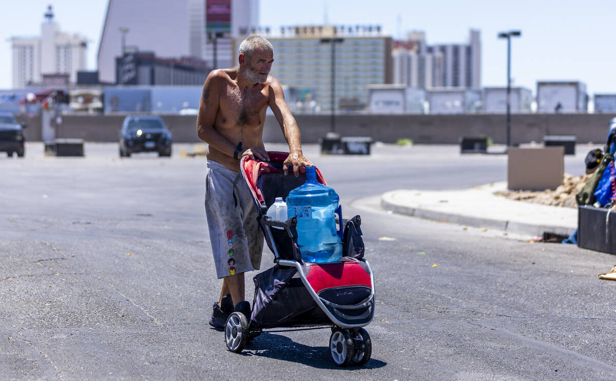 A homeless man wheels a jug of water to his encampment along about E. Washington Ave. as Vegas ...