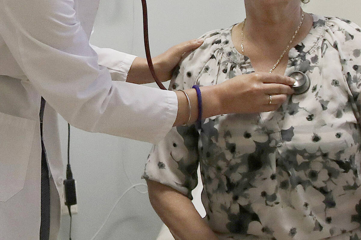 FILE - A doctor examines a patient at a clinic in Stanford, Calif., on April 9, 2019. Patients ...