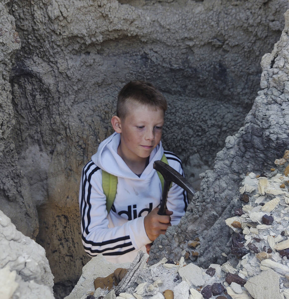 In this photo provided by Giant Screen Films, Jessin Fisher digs for fossils on public lands ne ...