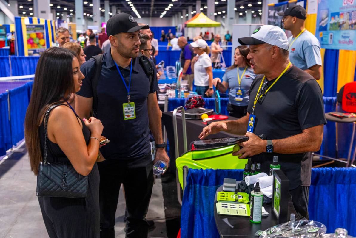 Richard Eklund with Bear Lake Pickleball, right, talks about their paddle cleaning product to a ...