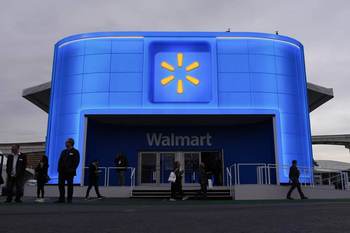 People walk by the Walmart booth during the CES tech show Tuesday, Jan. 9, 2024, in Las Vegas. ...