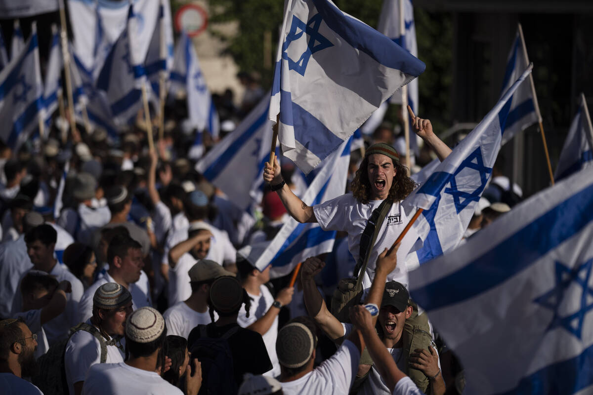 Israelis wave national flags during a march marking Jerusalem Day, an Israeli holiday celebrati ...