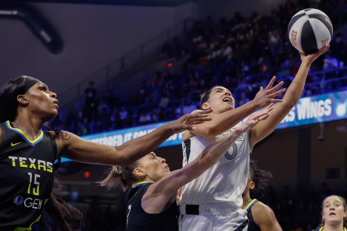 Las Vegas Aces guard Kelsey Plum (right) is fouled by Dallas Wings guard Sevgi Uzun (center) as ...