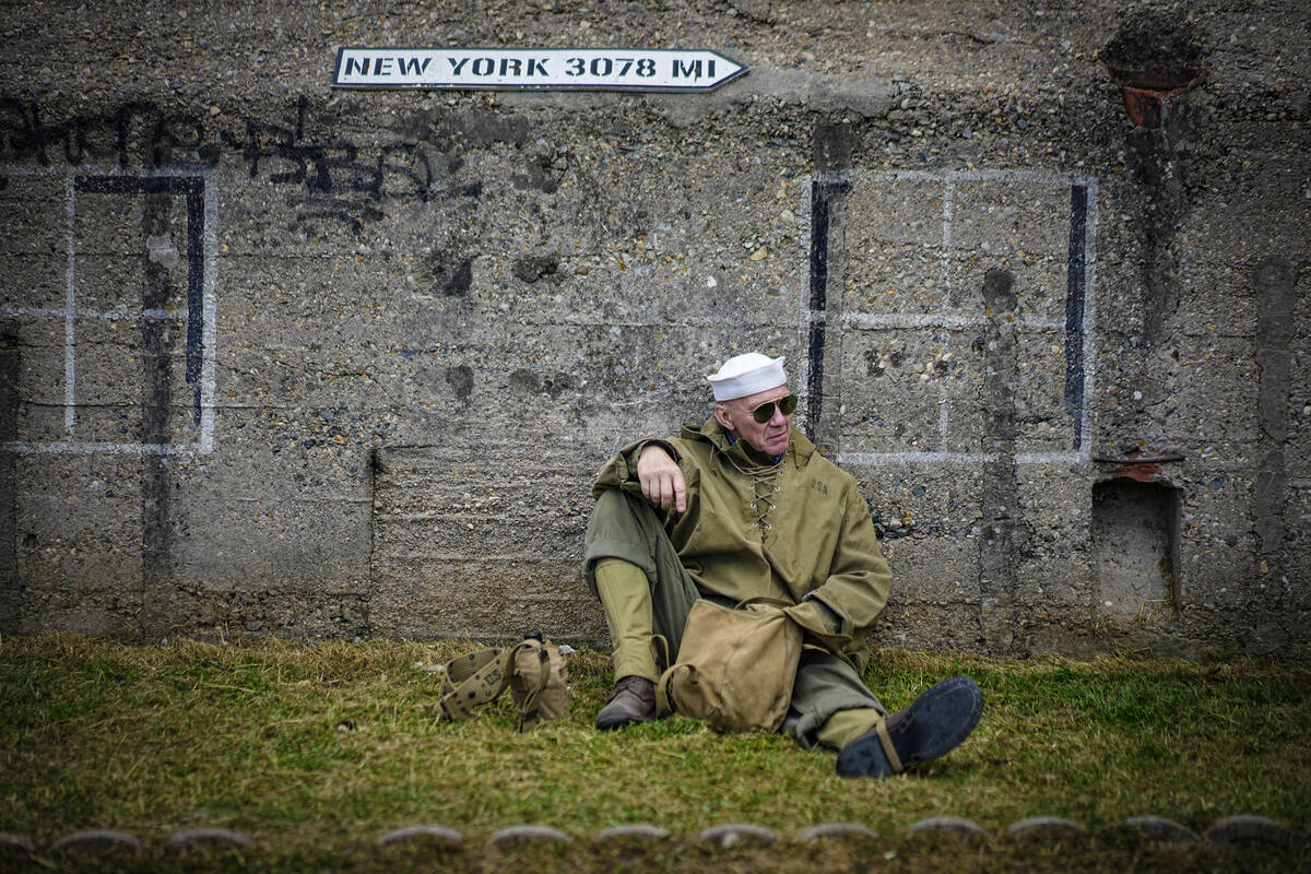 A reenactor rests in front of Utah beach during the ceremonies marking the 80th anniversary of ...
