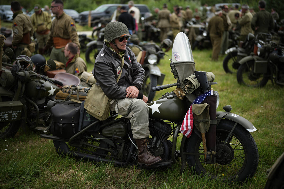 A reenactor sits on a US army vintage Harley Davidson motorbike at Utah Beach near Sainte-Marie ...