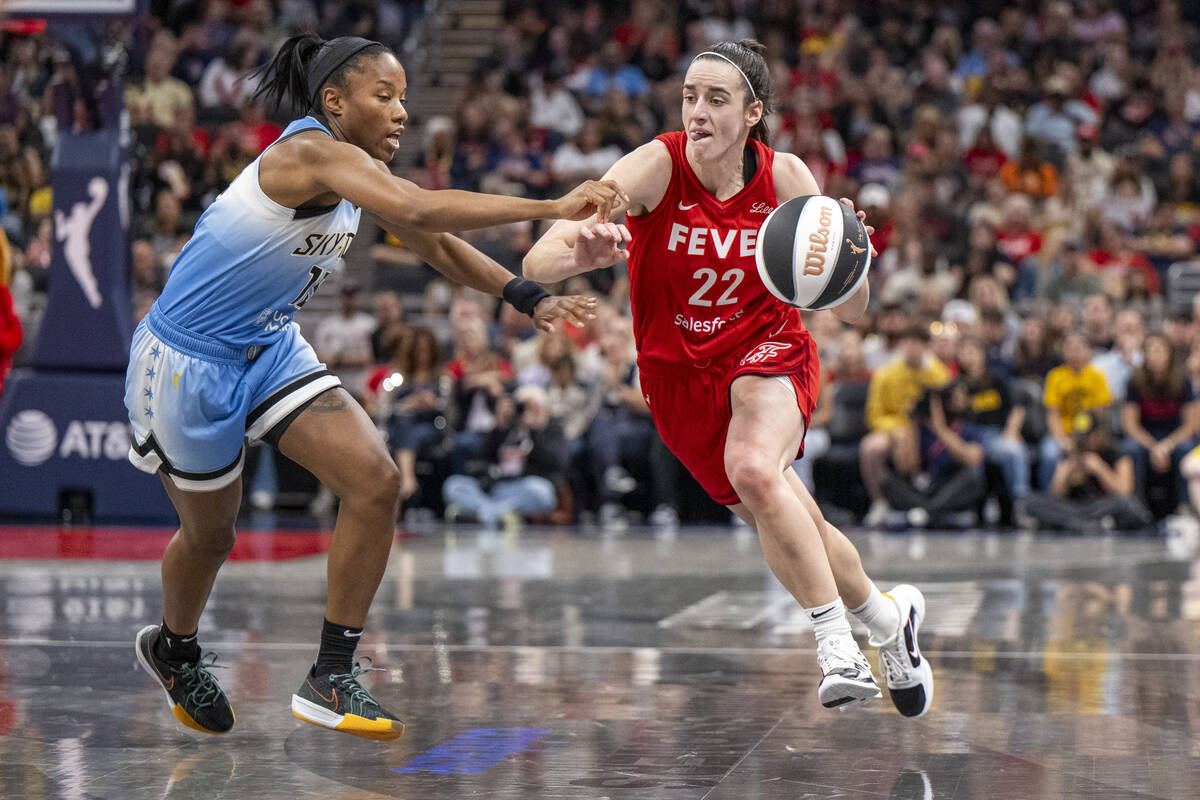 Indiana Fever guard Caitlin Clark (22) makes a move around the defense of Chicago Sky guard Lin ...