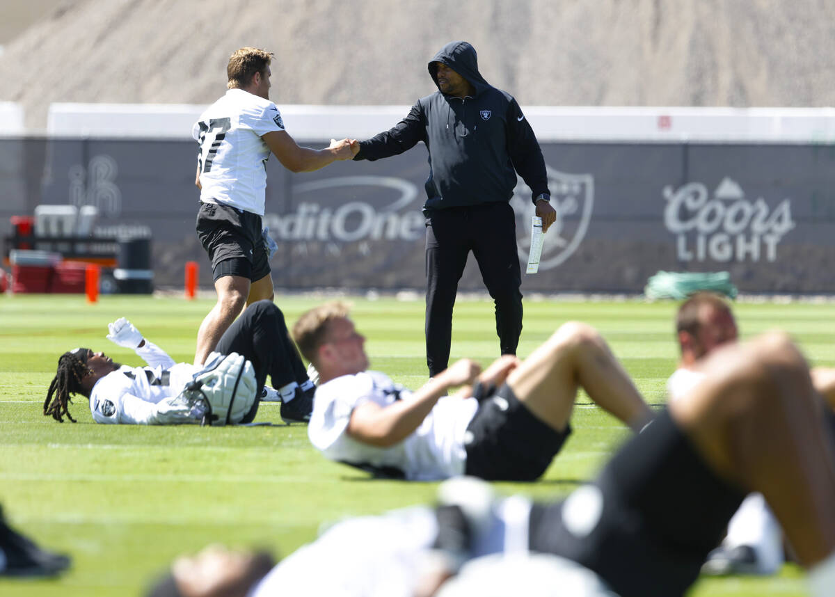 Raiders head coach Antonio Pierce shakes hands with tight end Michael Mayer (87) during team's ...