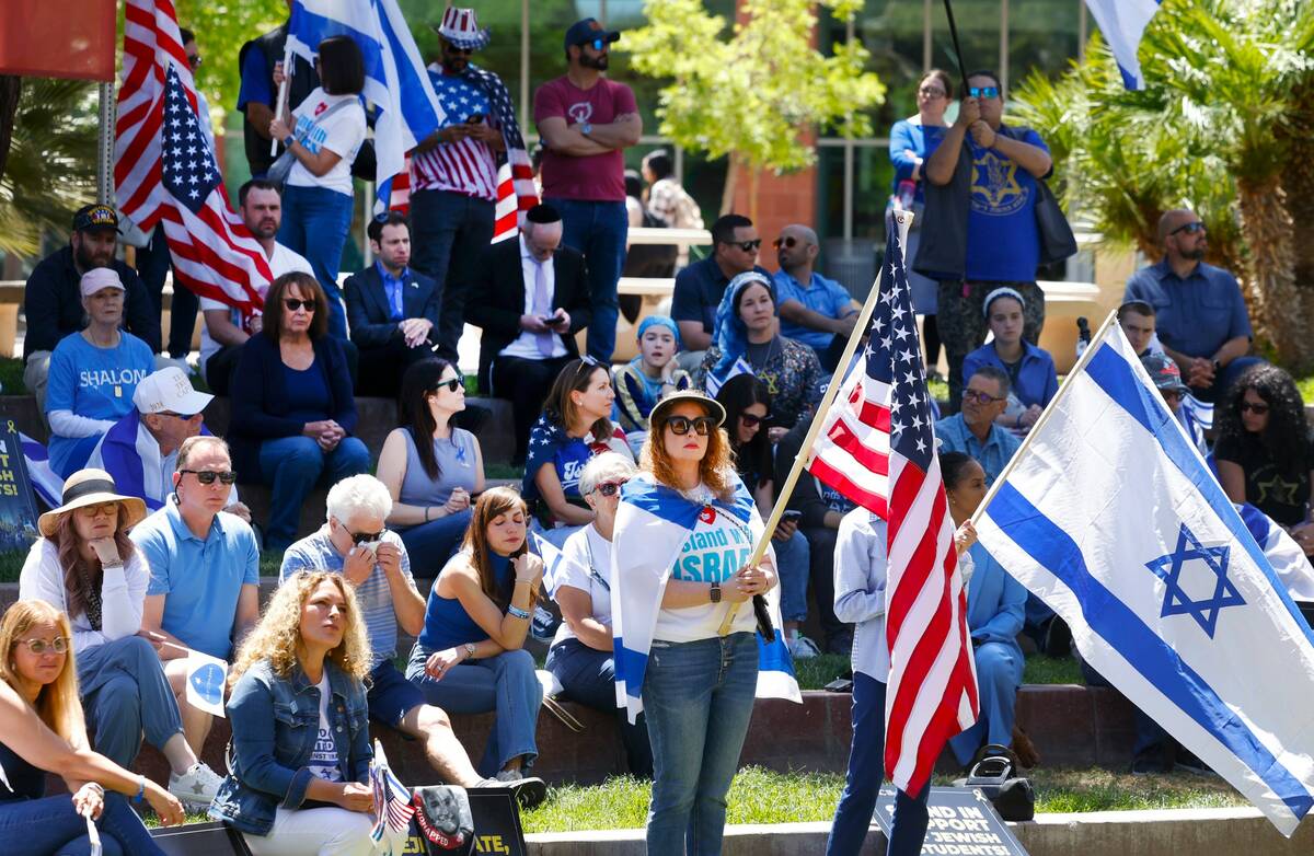 Jennifer Courier, center, holds a U.S. flag while joining others at a rally against antisemitis ...