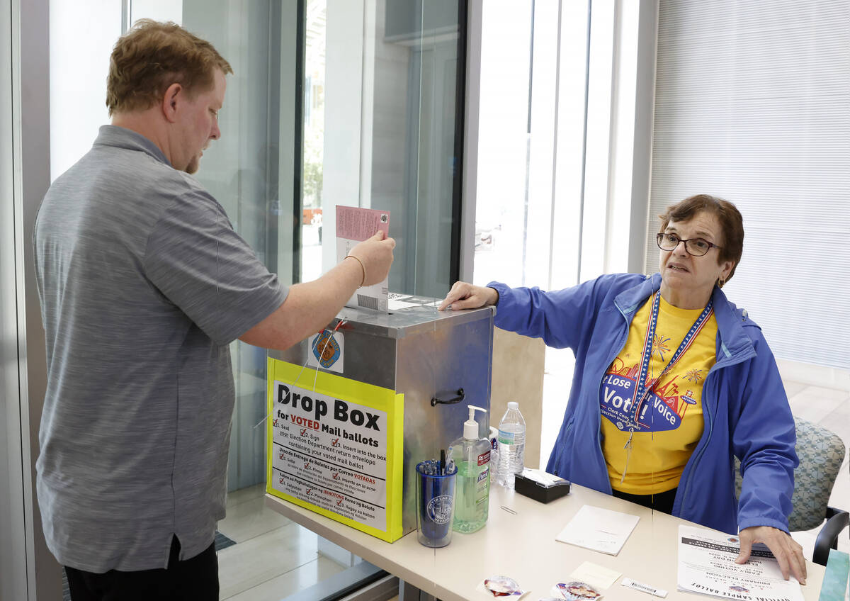 John Goodnow of Las Vegas casts his ballot at a drop box as Beverly Mourachian, a volunteer pol ...