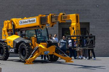 Attendees check out a JCB Loadall in the parking lot during an event at the Southern Nevada Tra ...