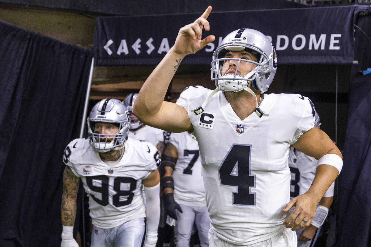 Raiders quarterback Derek Carr (4) and defensive end Maxx Crosby (98) take the field with teamm ...