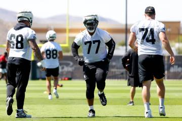 Raiders players, including offensive Tackle Thayer Munford Jr. (77) warm up during organized te ...