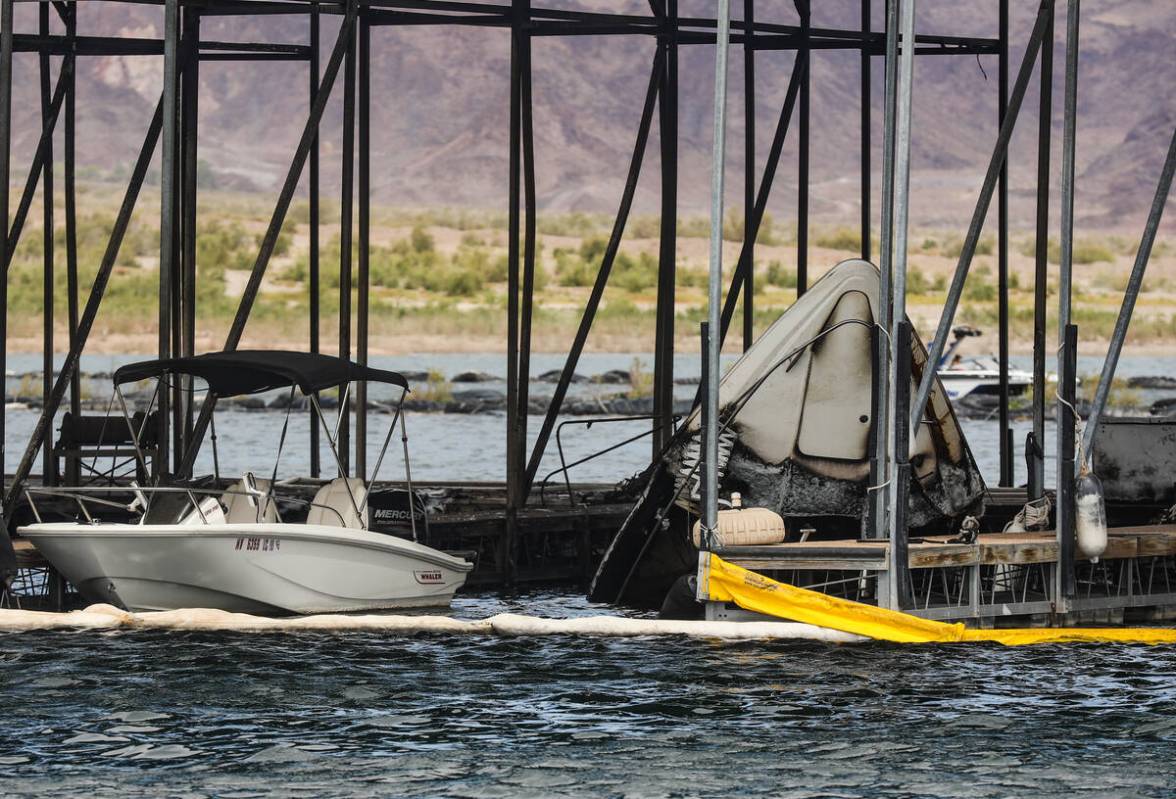 The bow of a sunken boat peaking out of the water at the scene where a fire sank 10 boats, did ...