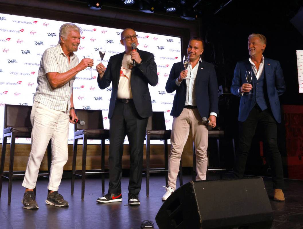 Sir Richard Branson, left, president and founder of Virgin Group, toasts, from second from left ...