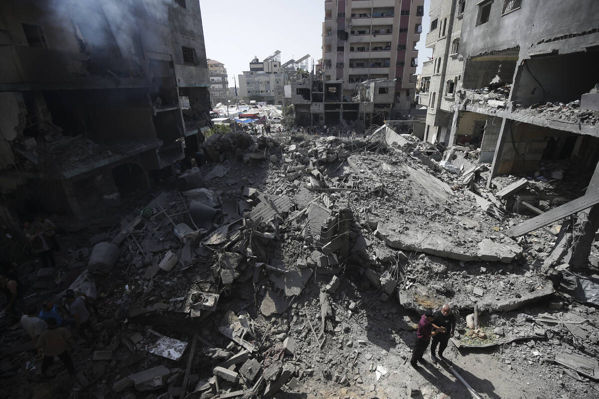 Palestinians look at the aftermath of the Israeli bombing in Nuseirat refugee camp, Gaza Strip, ...