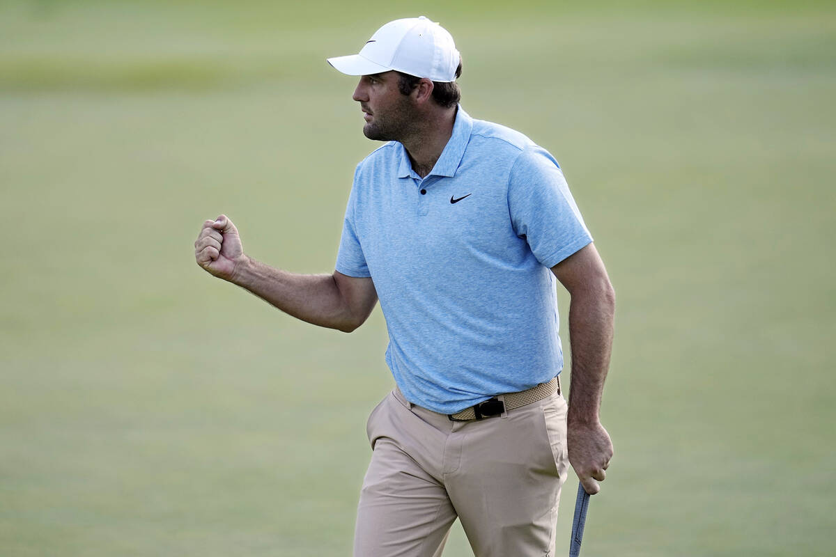 Scottie Scheffler pumps his fist after putting on the 16th green during the final round of the ...