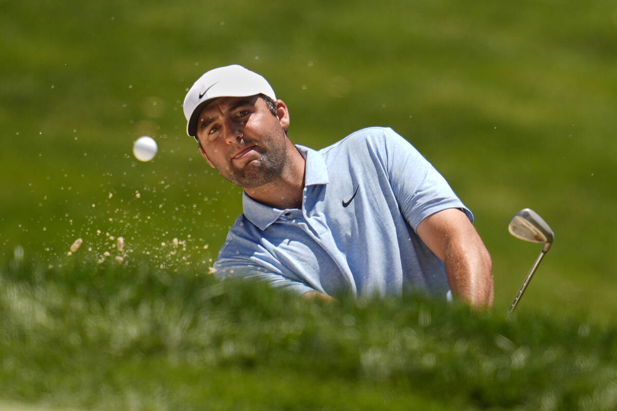 Scottie Scheffler hits from a bunker onto the fourth green during the final round of the Memori ...