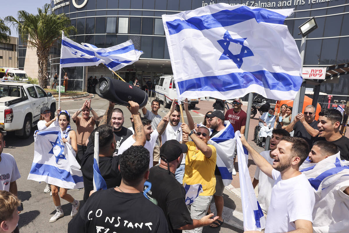 People wave Israeli flags as they celebrate after hostages who were kidnapped in a Hamas-led at ...