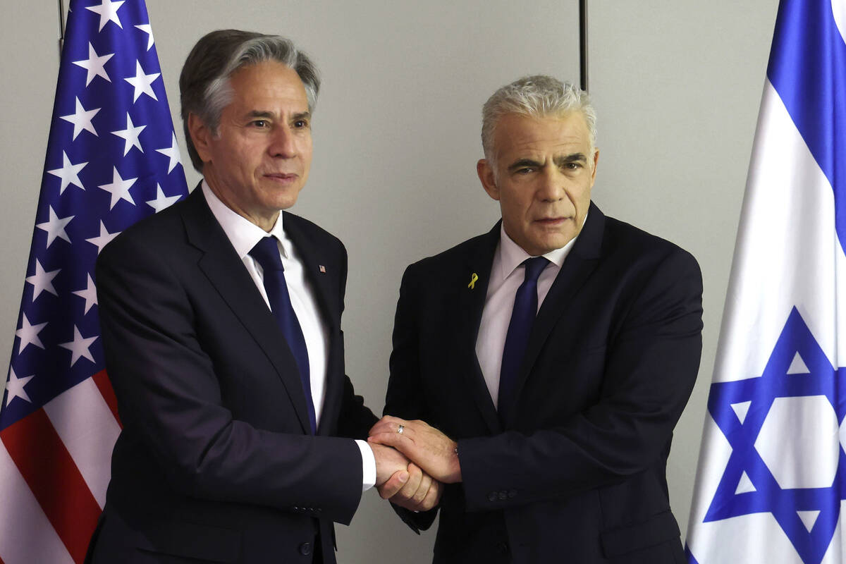 U.S. Secretary of State Antony Blinken, left, shakes hands with Israeli opposition leader Yair ...