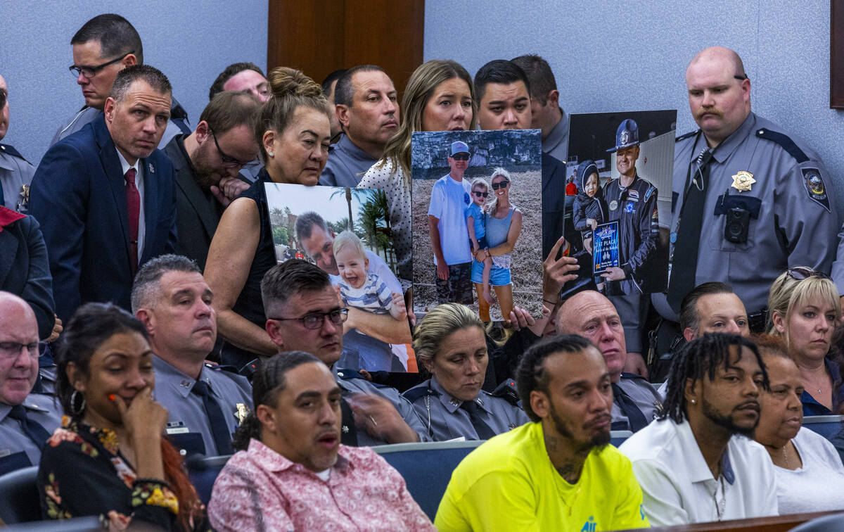 Supporters hold photos of Nevada Highway Patrol trooper Michael Abbate’s family during t ...