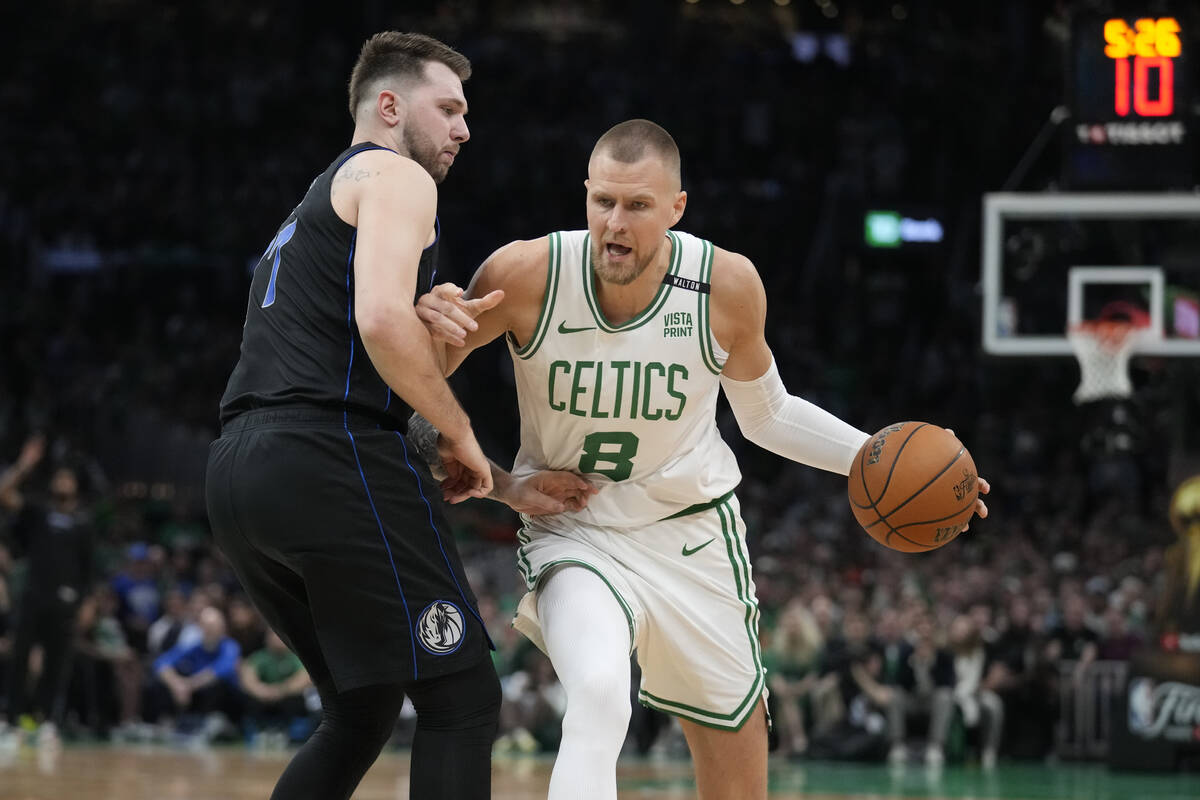 Boston Celtics center Kristaps Porzingis (8) drives against Dallas Mavericks guard Luka Doncic ...