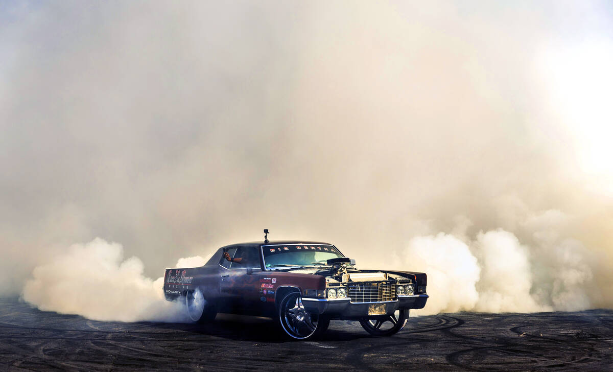 A driver participates in a Hoonigan drifting and burning event during the second day of SEMA at ...