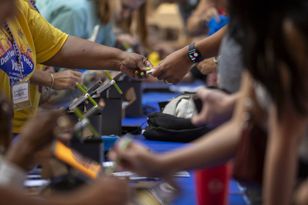 Voters fill out documents before casting their ballot during the Nevada Primary Day Elections o ...