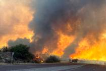 This image shows smoke and flames along a highway near Wickenburg, Ariz., Wednesday, June 12, 2 ...