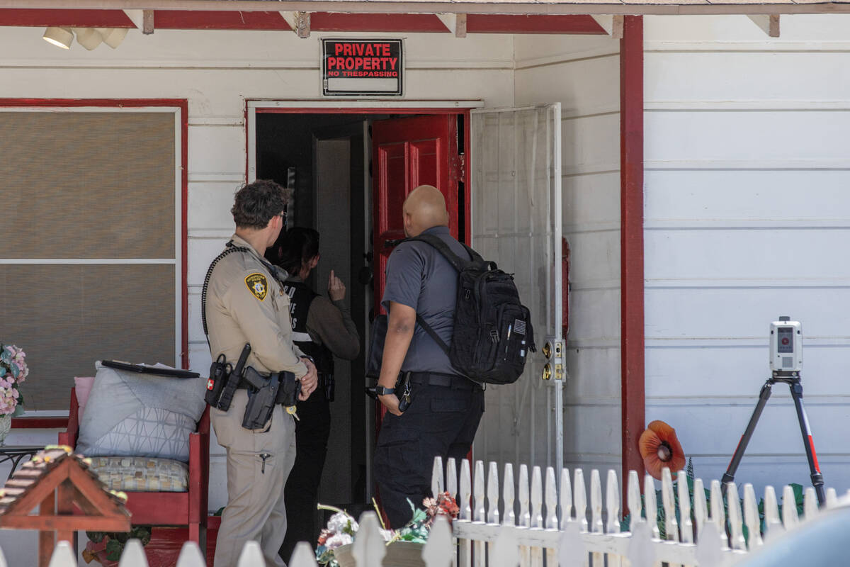 Members of the Las Vegas Metropolitan Police Department Homicide Section investigate the scene ...