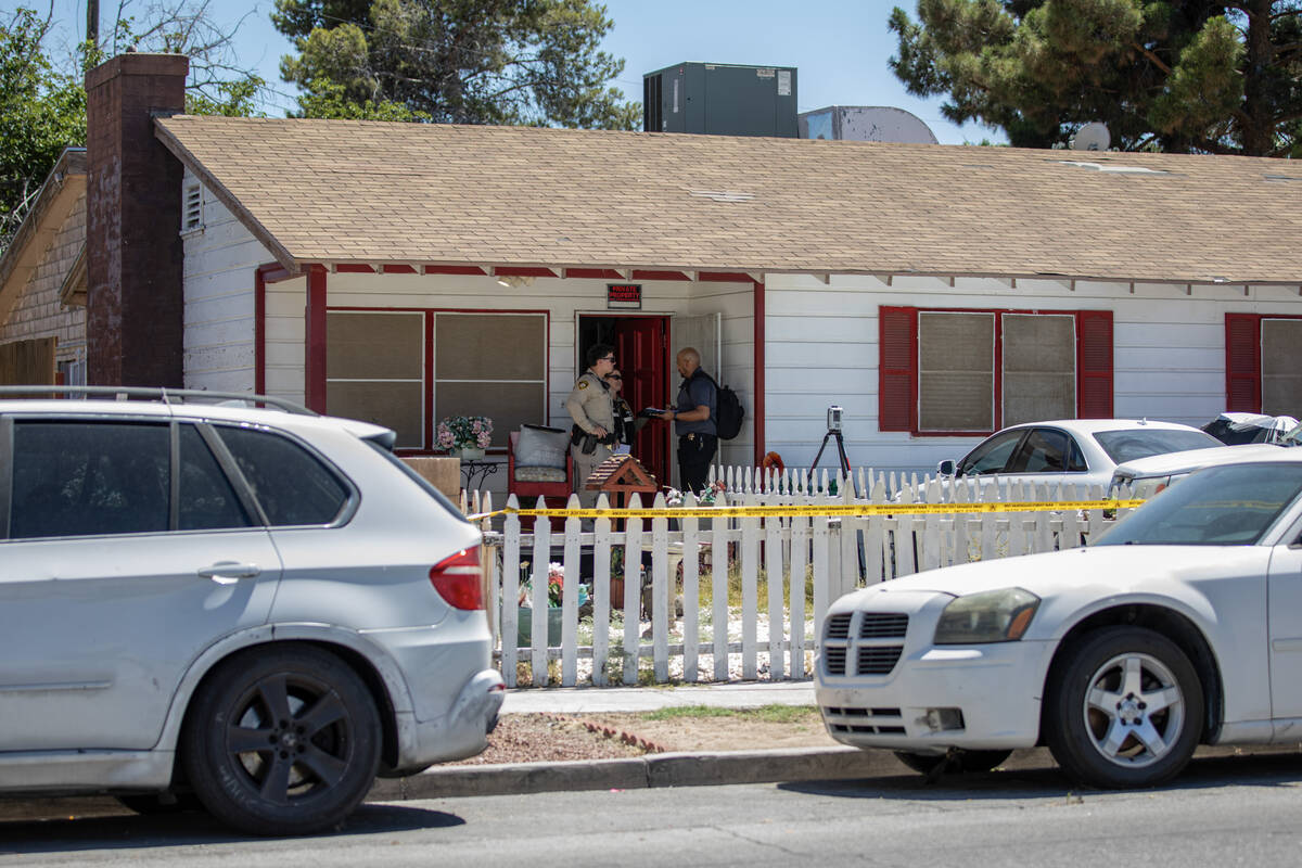 Members of the Las Vegas Metropolitan Police Department Homicide Section investigate the scene ...