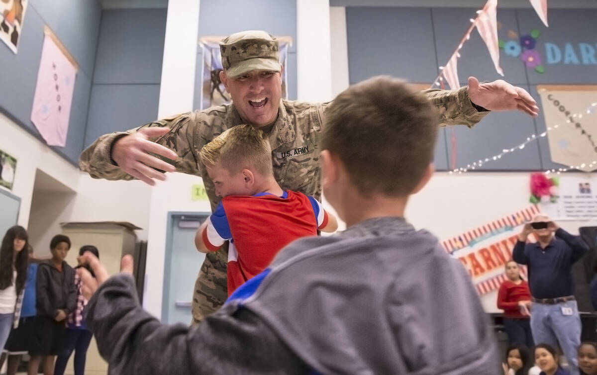 Maj. Beau Vinatieri gets a big hug from son's Jeau, 10, and Keaul, 8, in a surprise ceremony at ...