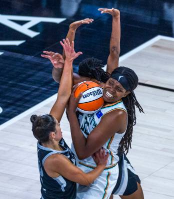 New York Liberty forward Jonquel Jones (35) is double-teamed by Aces guard Kelsey Plum (10) and ...