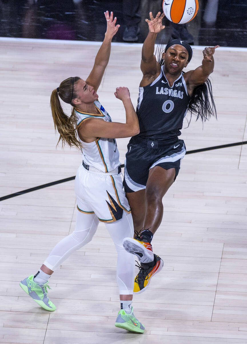 Aces guard Jackie Young (0) gets off a pass over New York Liberty guard Sabrina Ionescu (20) du ...