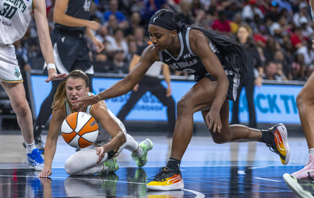 Aces guard Jackie Young (0) reaches for a loose ball as New York Liberty guard Sabrina Ionescu ...
