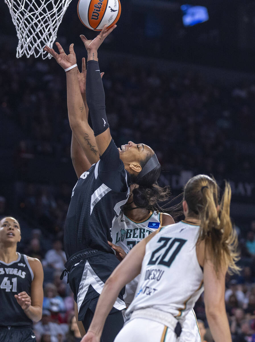 Aces center A'ja Wilson (22) gets to the basket as New York Liberty guard Sabrina Ionescu (20) ...