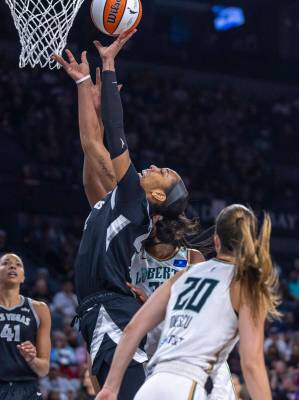 Aces center A'ja Wilson (22) gets to the basket as New York Liberty guard Sabrina Ionescu (20) ...