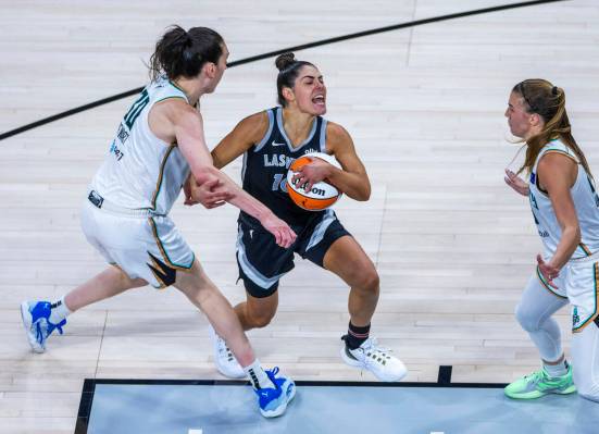 New York Liberty forward Breanna Stewart (30) fights with Aces guard Kelsey Plum (10) as she dr ...