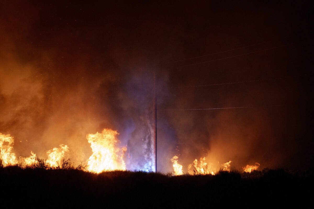 Power lines spark as a pole burns during the Post Fire on Saturday, June 15, 2024, in Gorman, C ...