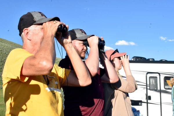 Visitors to Yellowstone National Park are seen looking for wildlife through binoculars in the L ...