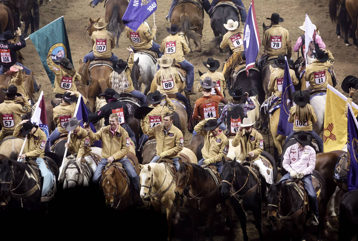 Competitors tip their hats to the crowd during the fifth go-round of the National Finals Rodeo ...