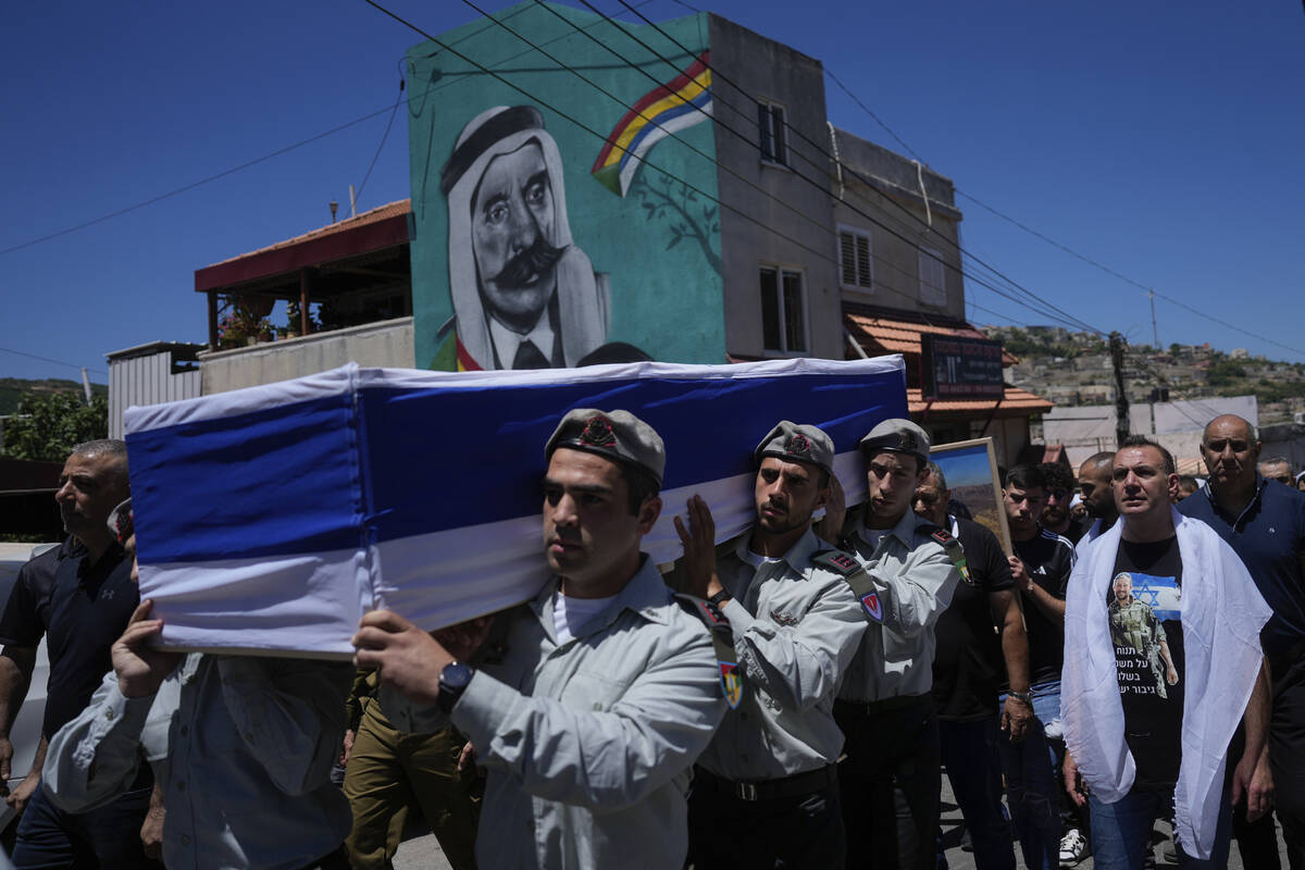 Israeli soldiers carry the flag-draped casket of Capt. Wassem Mahmoud during his funeral in the ...