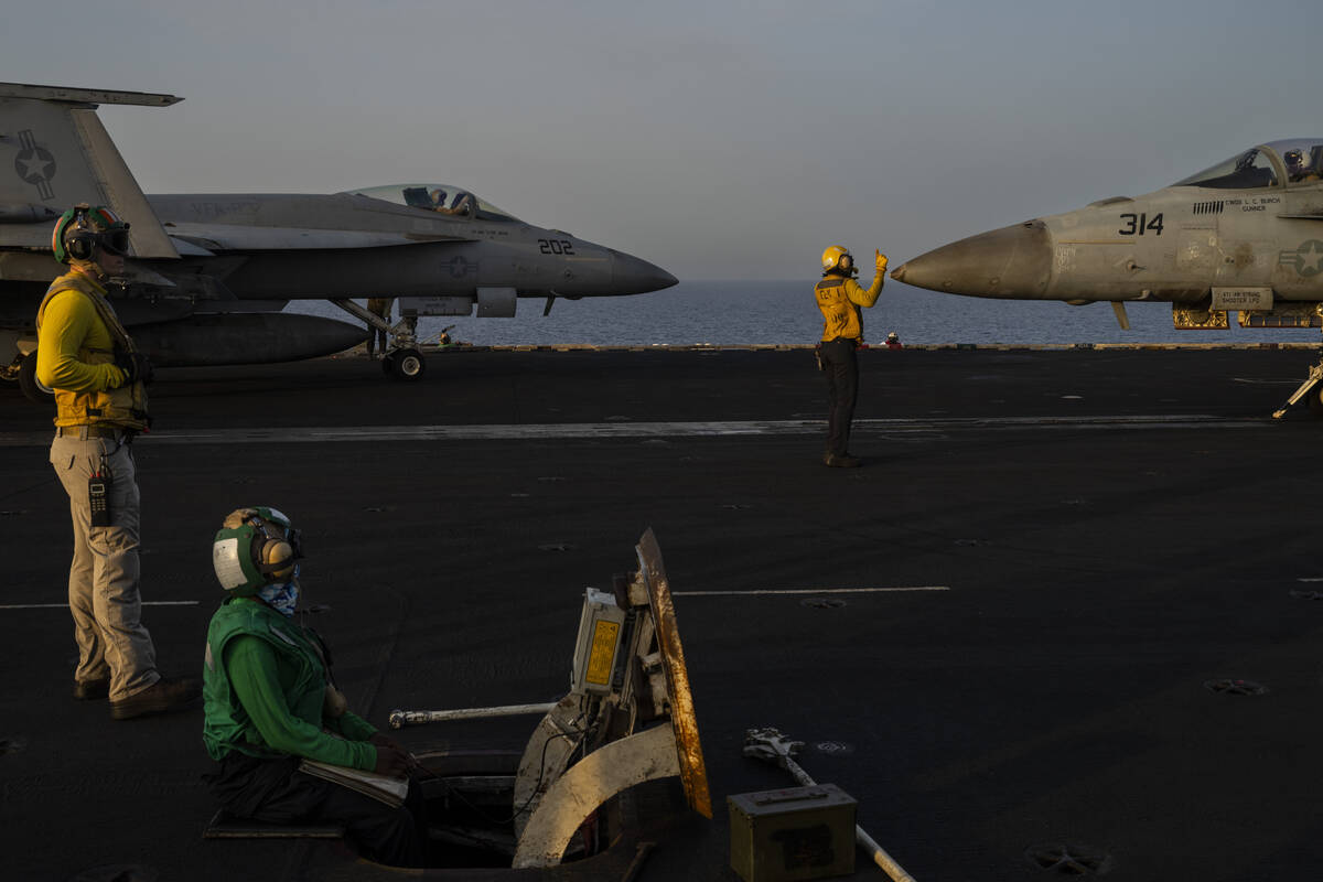 Fighter jets maneuver during take-off operations on the deck of the USS Dwight D. Eisenhower in ...