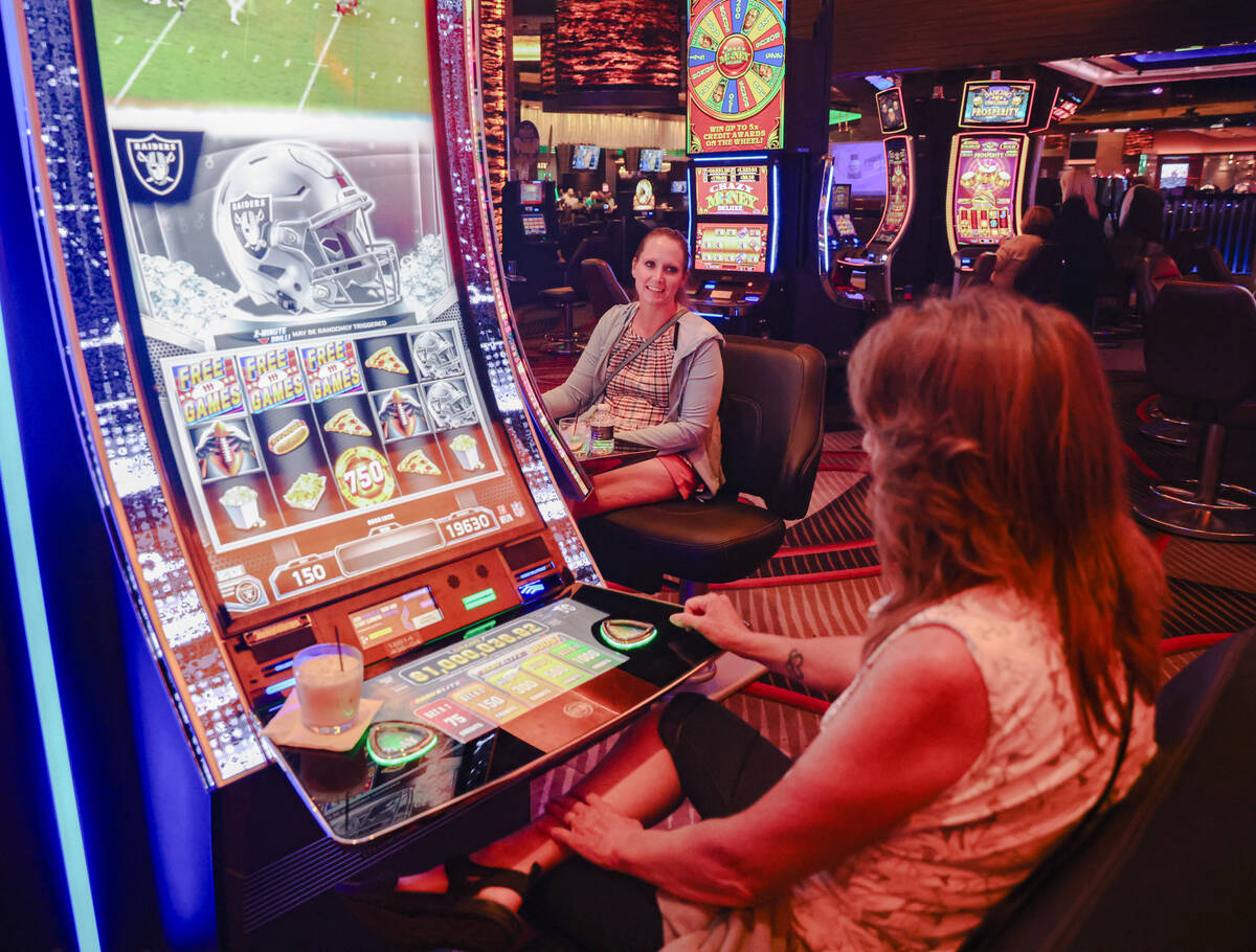 Pam Hillaker, right, plays the first Vegas NFL slot machine with her daughter Candice Low, cent ...